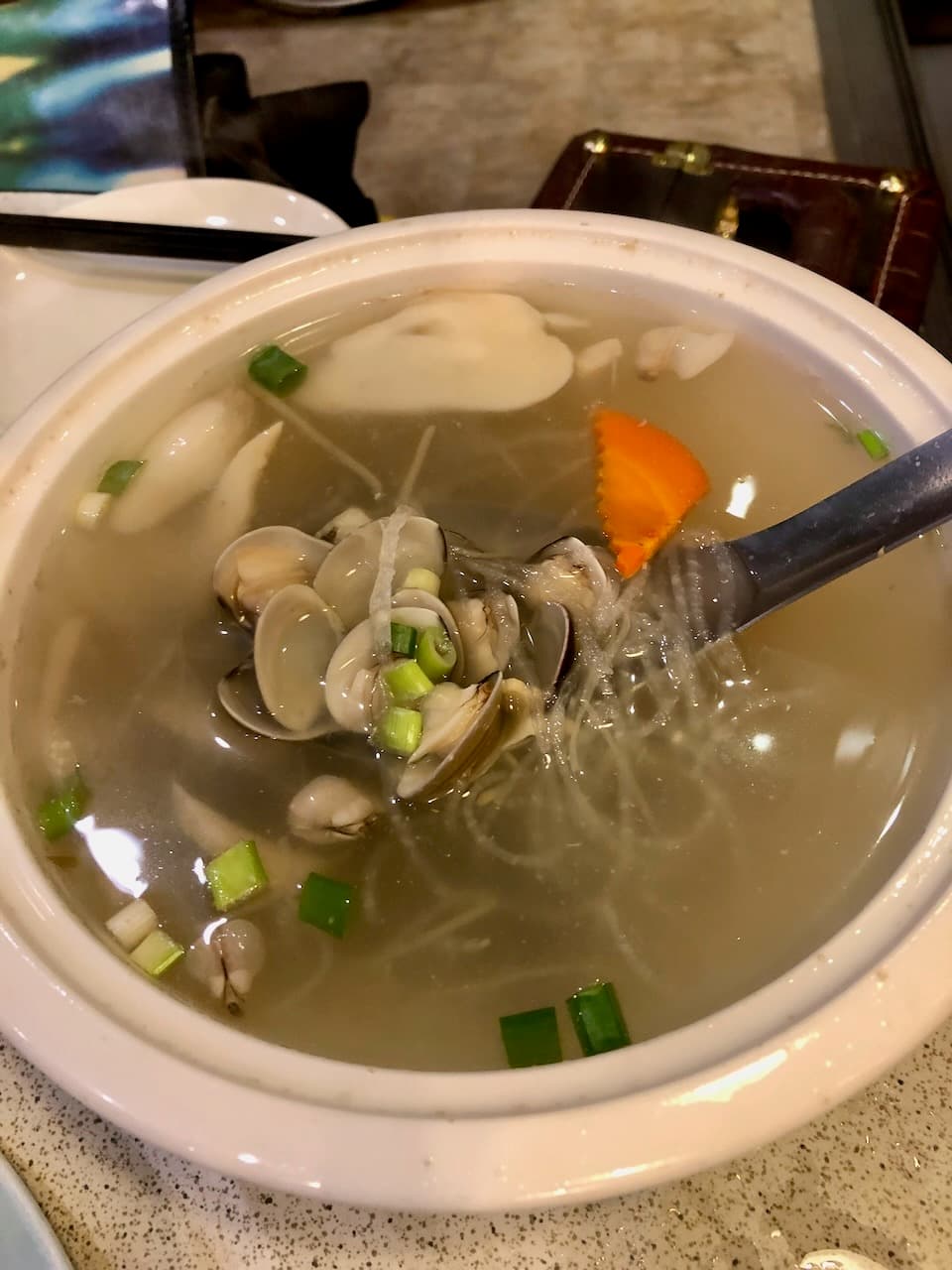 大灣碼頭的蛤蜊冬粉湯，湯匙舀起一匙蛤蜊