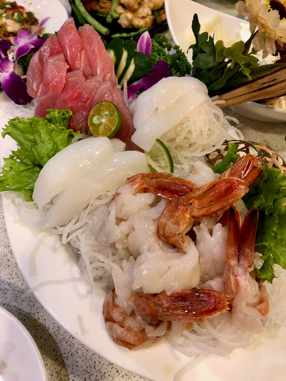 大灣碼頭的生魚片拼盤，有鮪魚、花枝和生蝦，鋪在白蘿蔔絲上