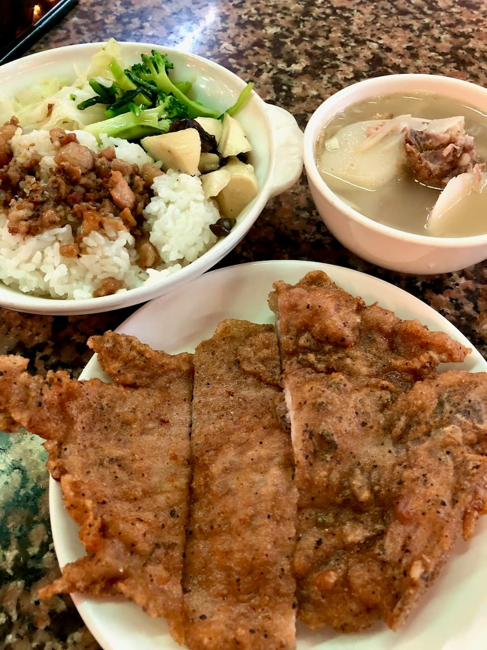 東一排骨的排骨飯：排骨另外一盤，白飯淋肉燥配青菜，旁邊一碗蘿蔔湯